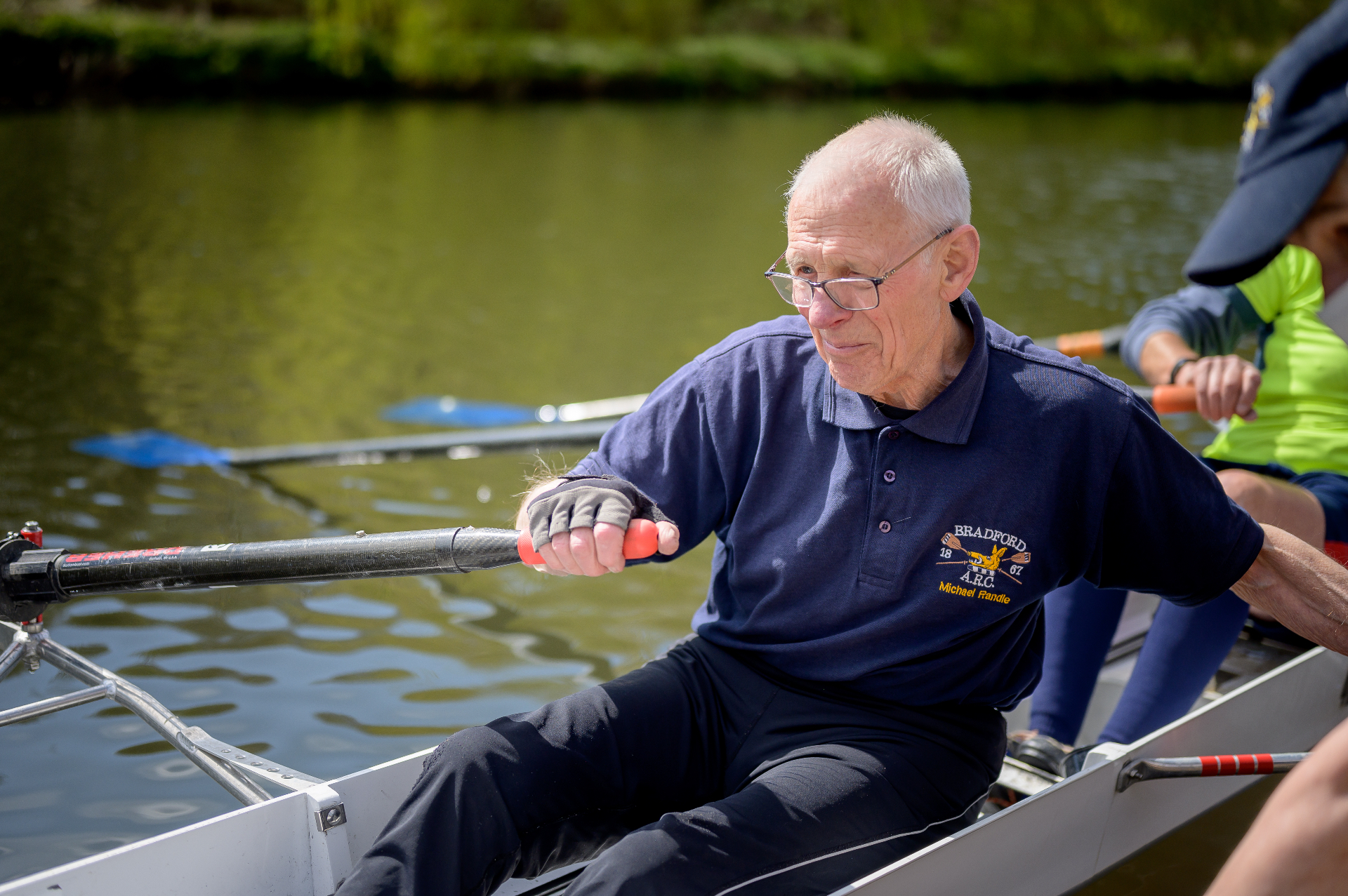An older adult rowing on the river — staying active and breathing well.