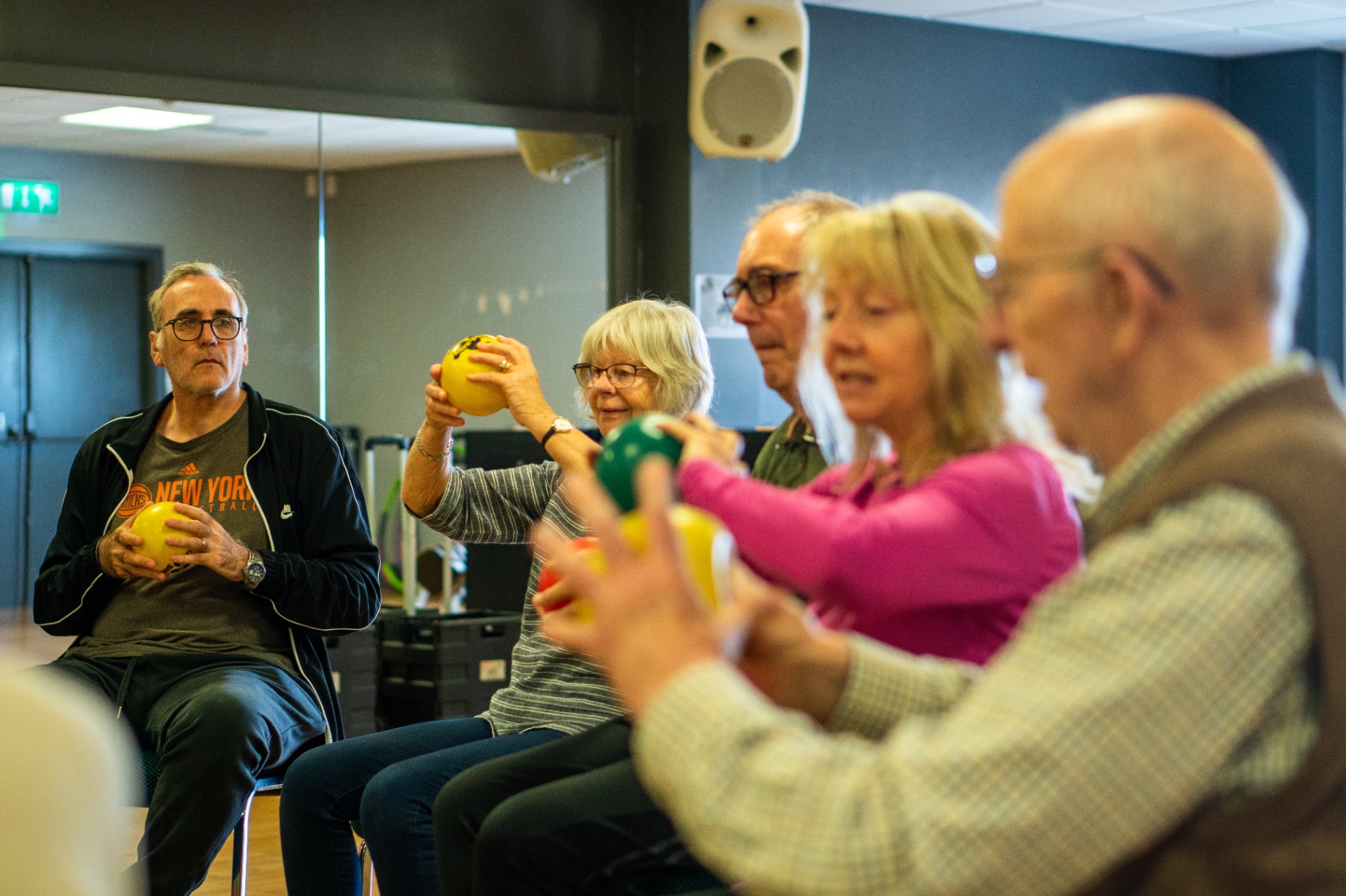 A seated exercise group using therapy balls in a class.