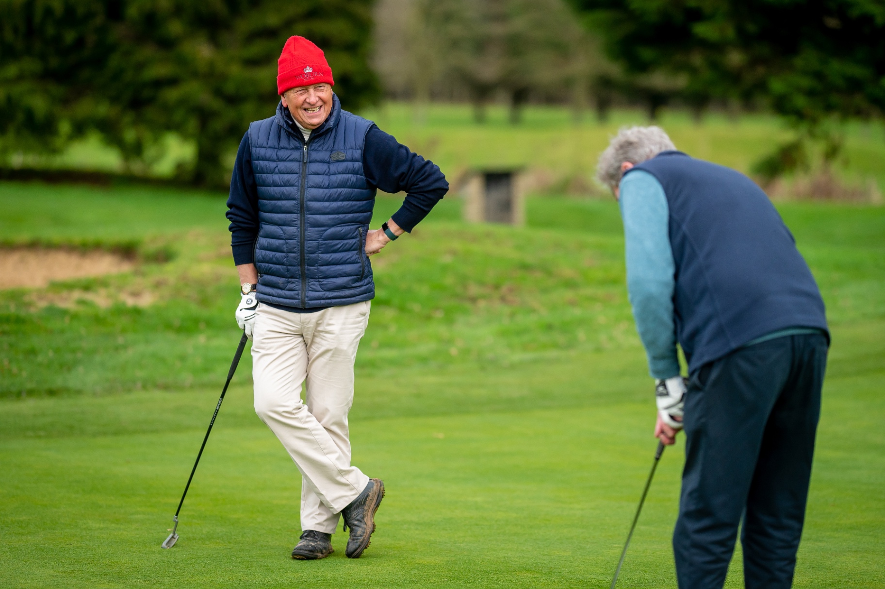 An older man smiling on a golf course, reflecting a return to valued activity.